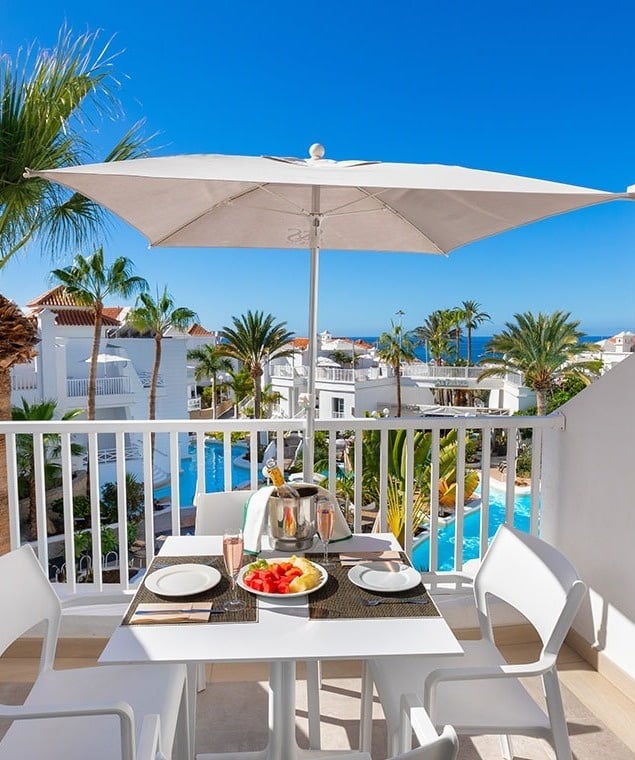people sit at tables under a sign that says alfresco