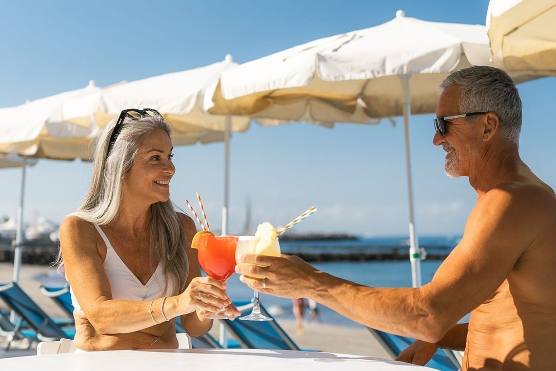 a woman in a bathing suit sits on the edge of a swimming pool