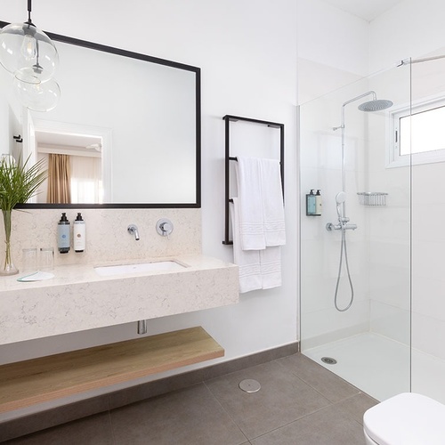 a bathroom with a walk in shower and a sink