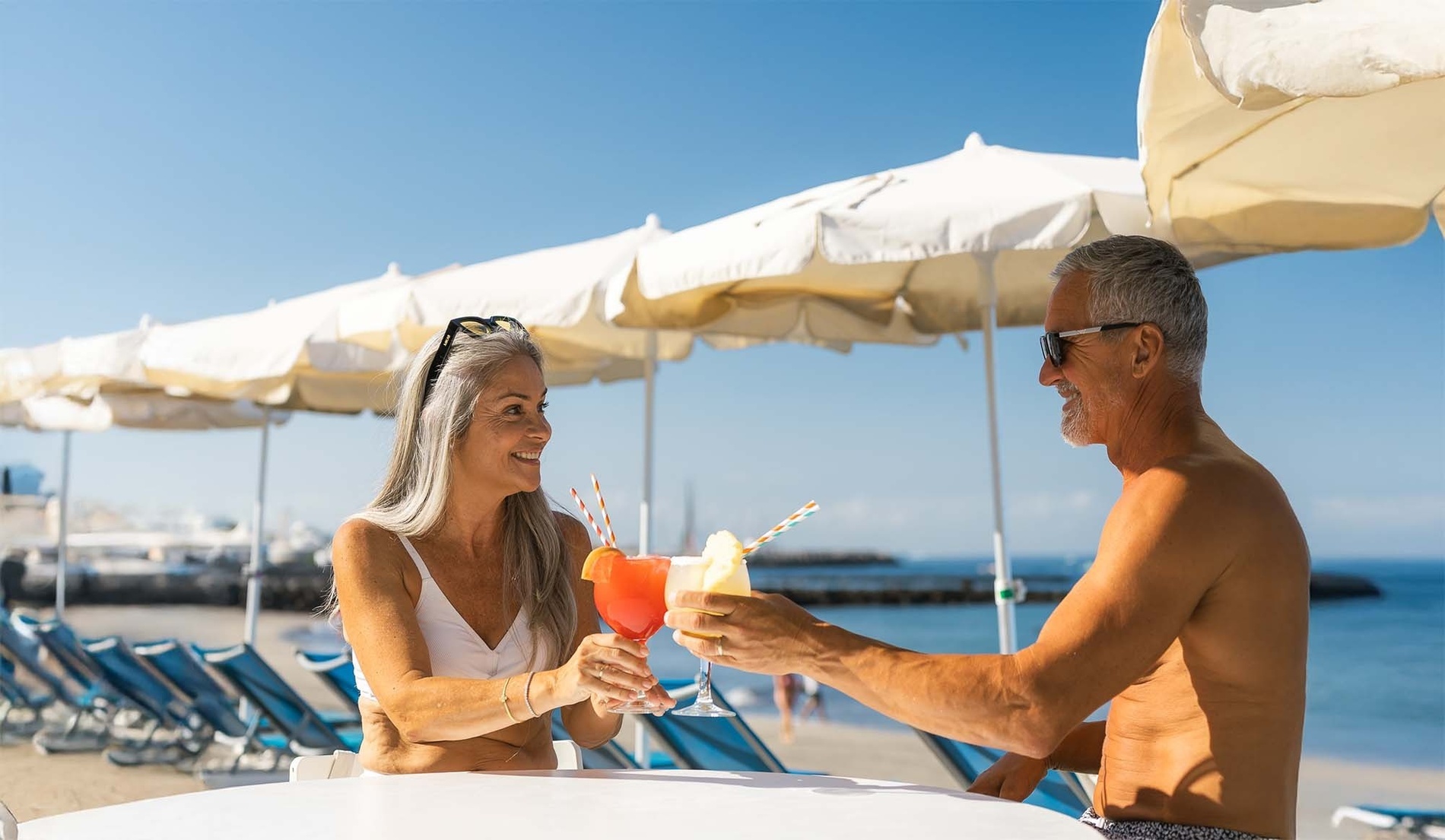 a woman in a hat sits on the edge of a swimming pool