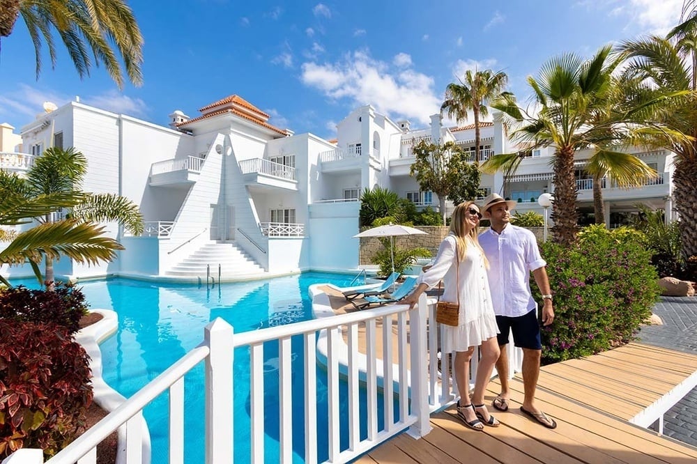 a group of people walking on a beach carrying surfboards