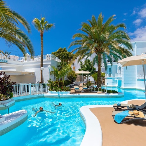 a woman wearing a straw hat and sunglasses sits by a pool