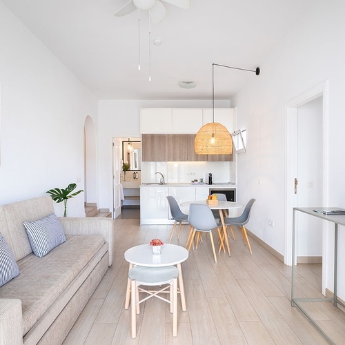 a living room with a couch and a picture of the ocean on the wall