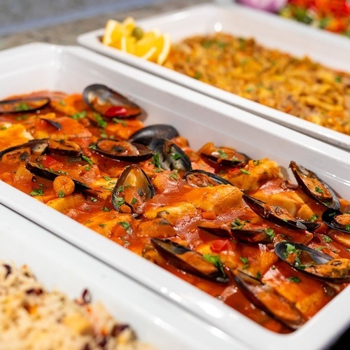 a tray of food with mussels in a sauce