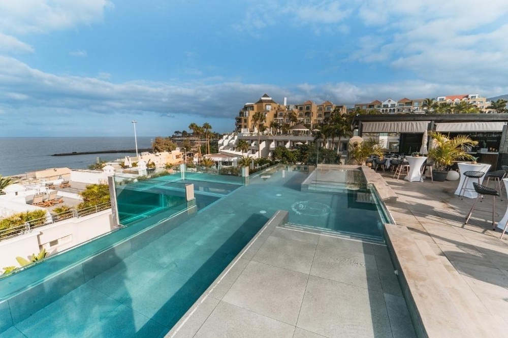 una mesa con un plato de frutas y un vaso de yogur