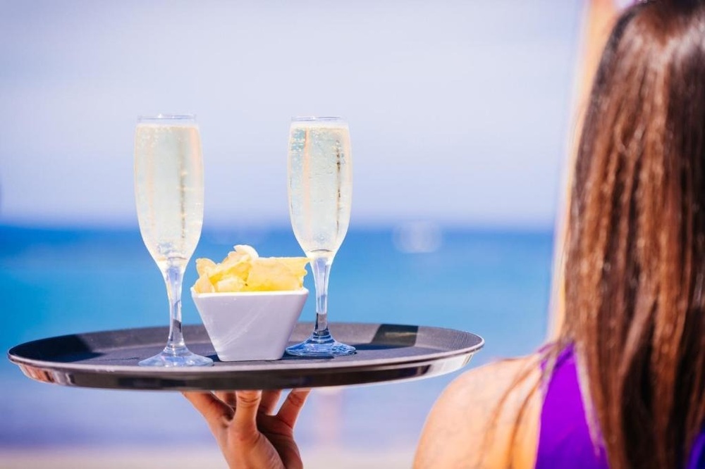 una gran piscina azul está rodeada de edificios blancos y palmeras .