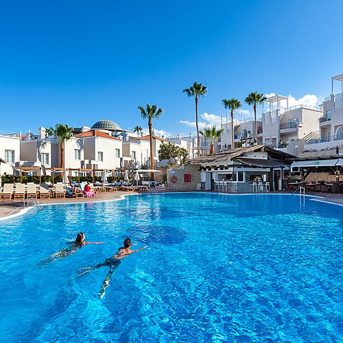Sand & Sea: Los Olivos Beach Resort: Piscina de hotel con palmeras y parejas nadando, un paraíso vacacional.