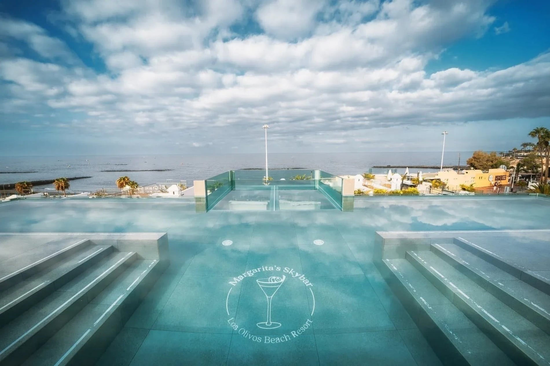 Piscina infinita con vista al mar y logo Margarita's Skybar en Los Olivos Beach Resort.