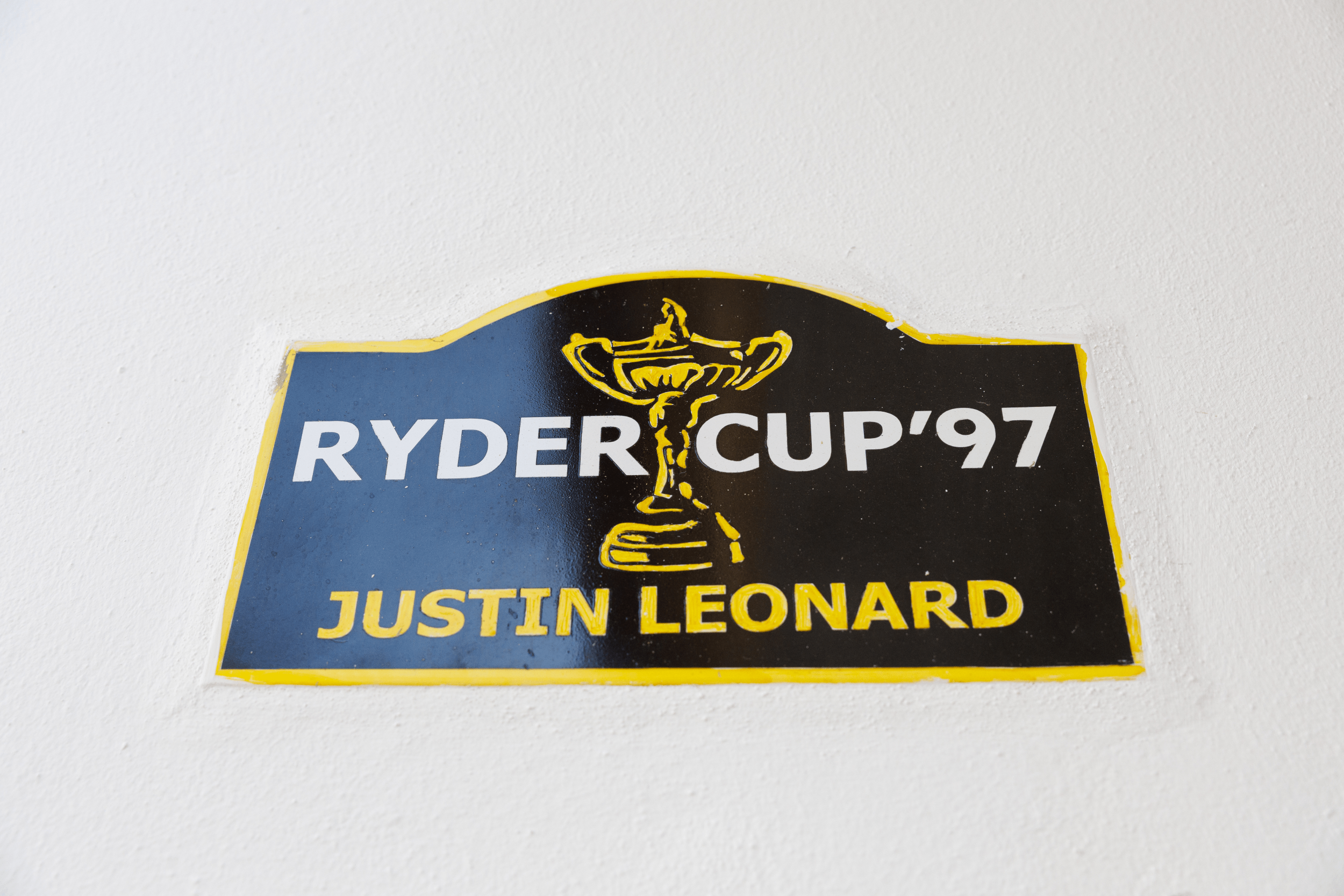 una placa negra y amarilla que dice ryder cup 97 justin leonard