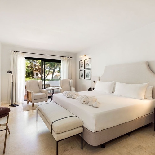 a hotel room with a king size bed and a bench