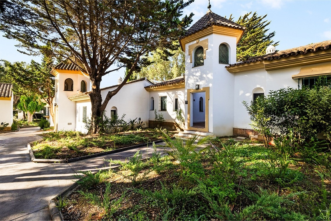 a large swimming pool surrounded by palm trees and umbrellas