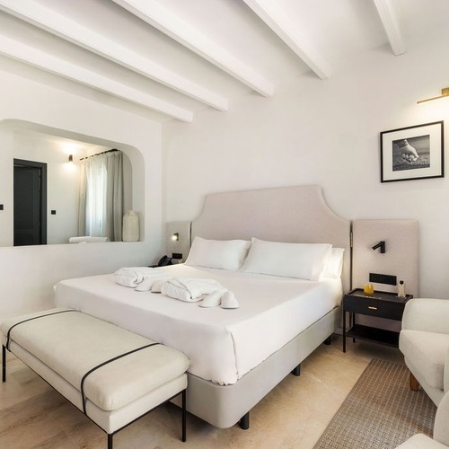 a hotel room with a large bed and a chair