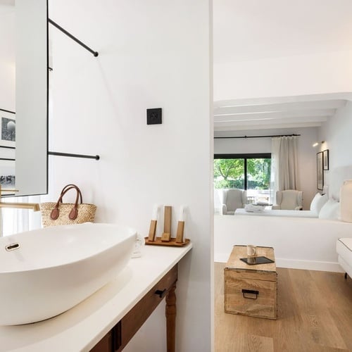 a bathroom with a sink and a couch in the background
