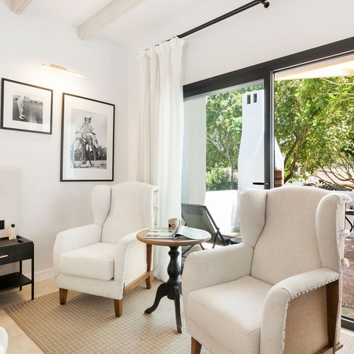 a room with two chairs and a table with a picture on the wall