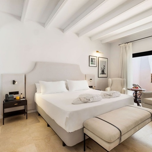 a hotel room with a large bed and chairs