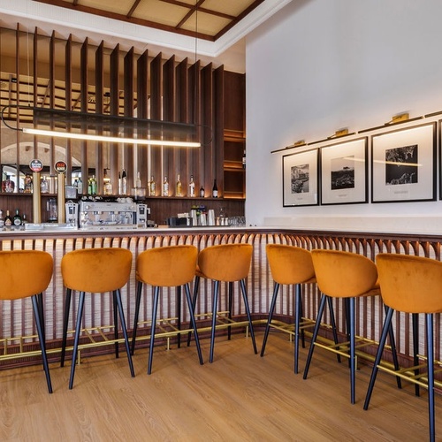 a row of orange bar stools in front of a bar