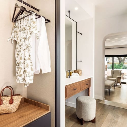 a white dress hangs on a rack next to a mirror