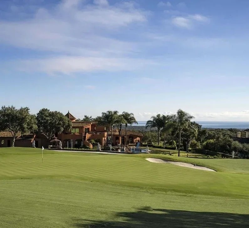 un campo de golf con una casa en el fondo