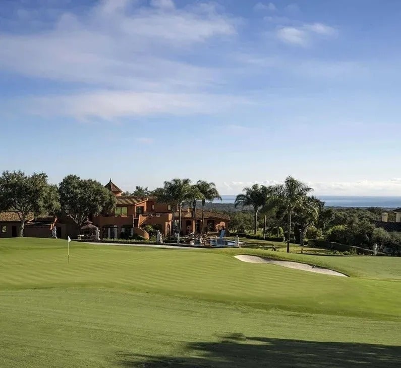 
                                    un campo de golf con una casa en el fondo