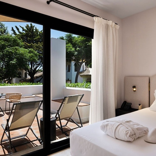 a bedroom with a sliding glass door leading to a balcony