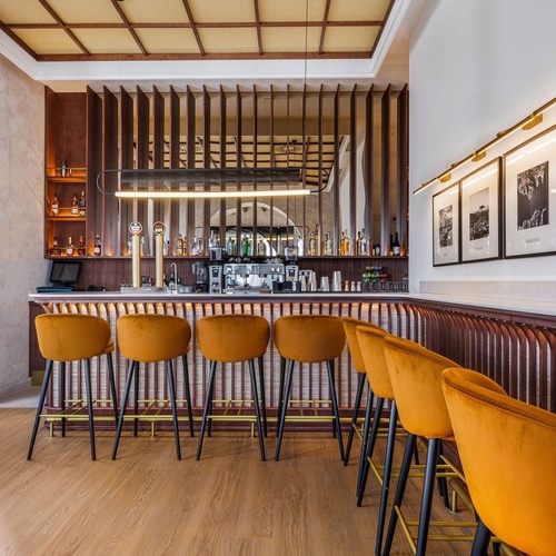 a bar with yellow chairs and a wooden ceiling