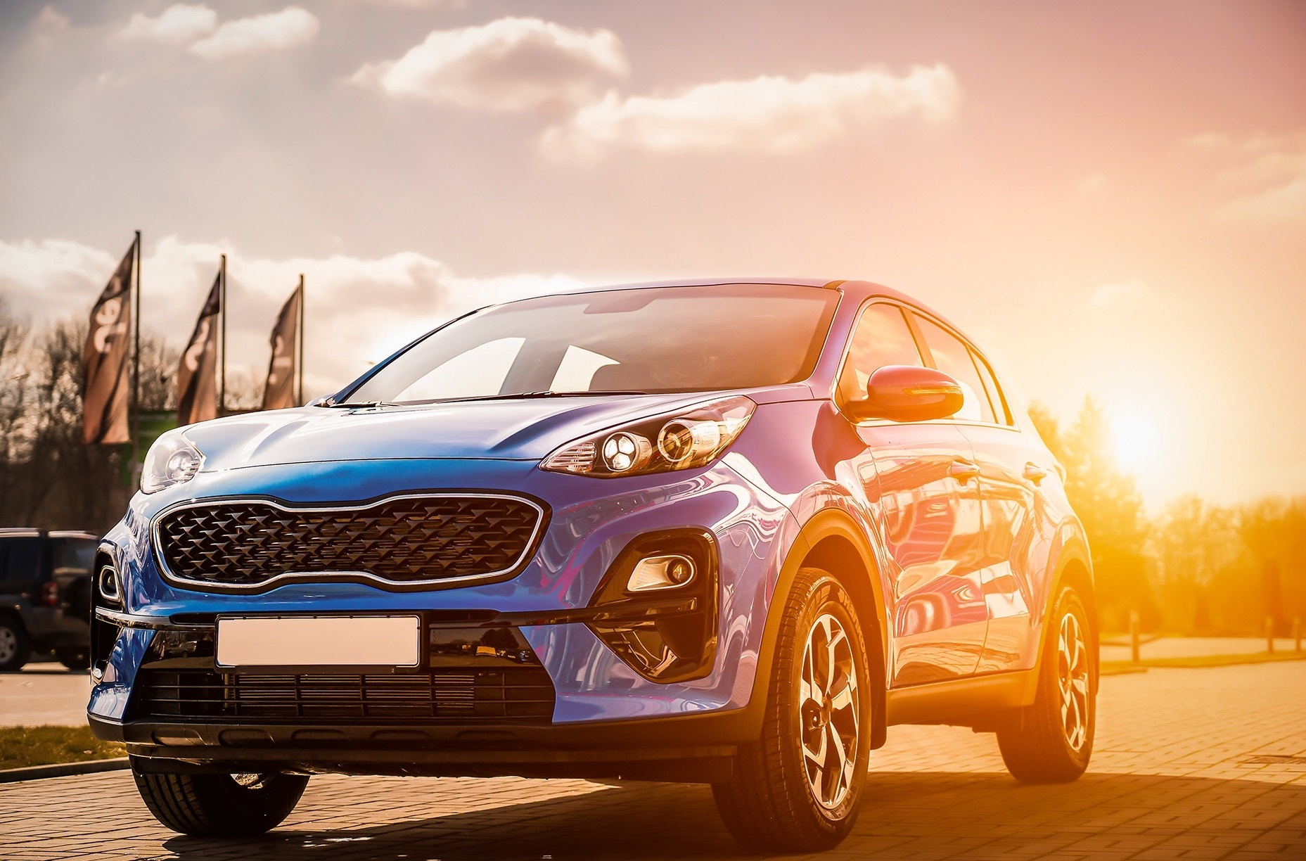 
                                    a blue car is parked in front of a sunset