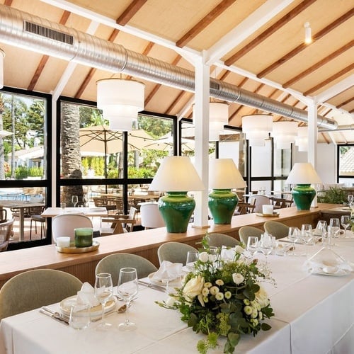 a long table in a restaurant with flowers on it