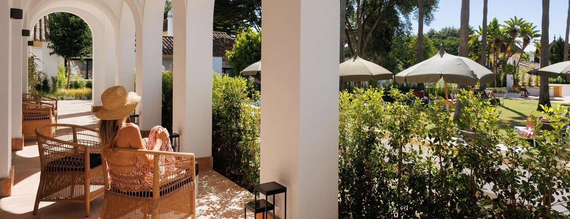 a large swimming pool surrounded by palm trees and umbrellas