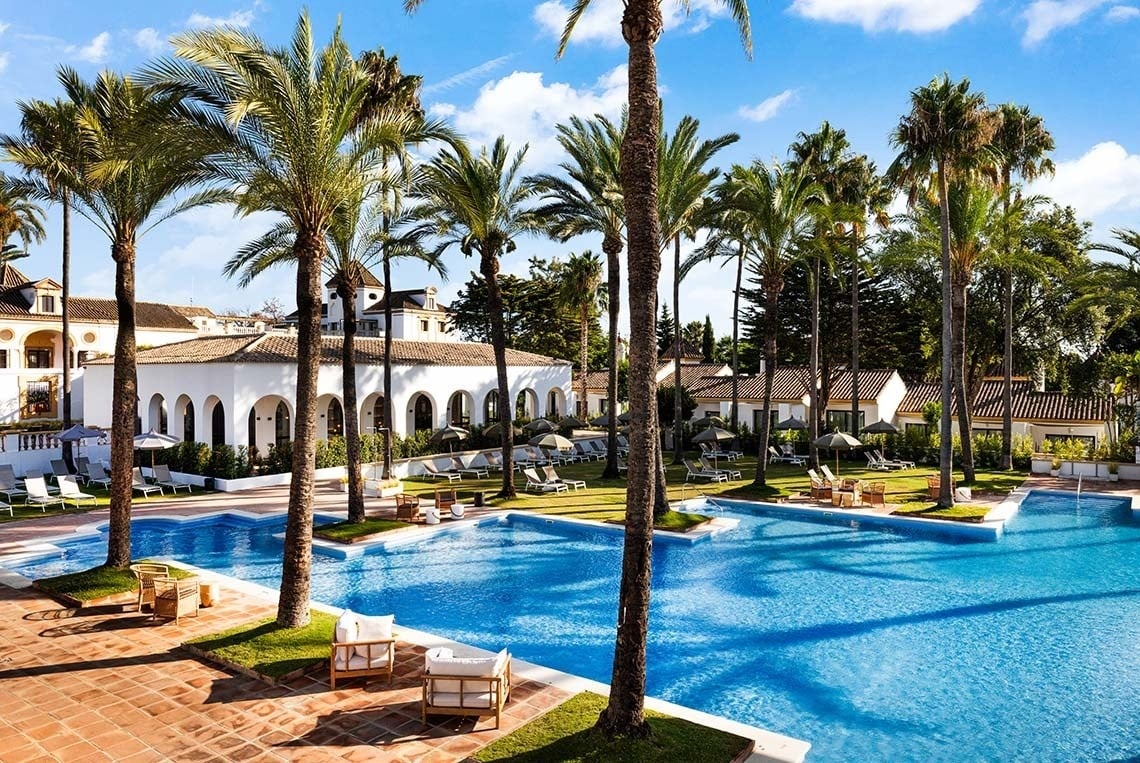 una gran piscina rodeada de palmeras en un resort