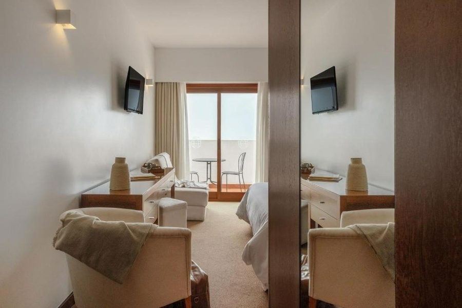 um quarto de hotel com duas cadeiras e uma mesa