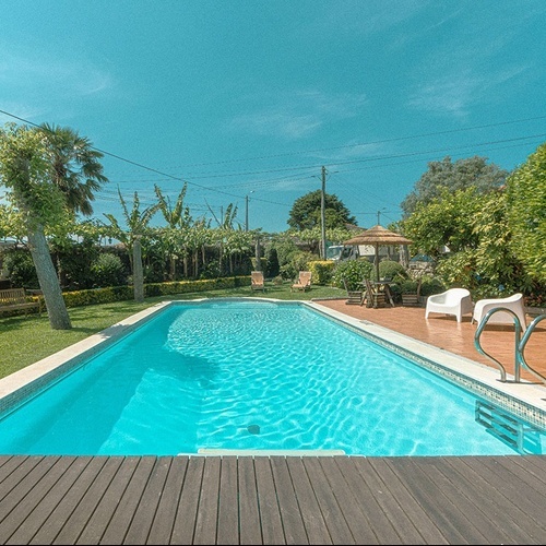 una gran piscina rodeada de muebles y árboles