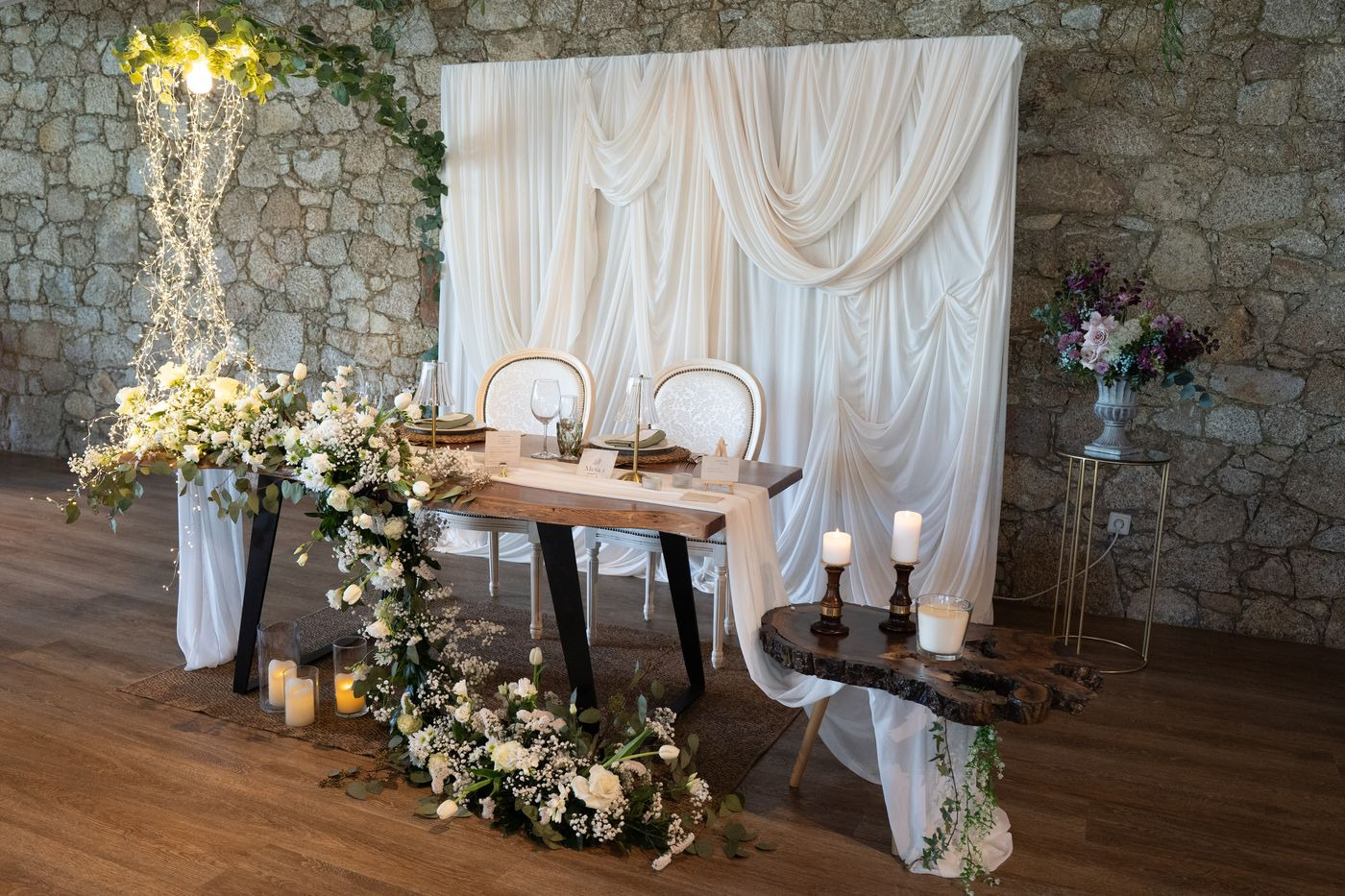 Mesa do casal com drapeado branco e velas no exterior.