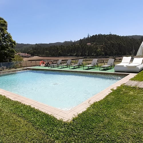 una piscina con un flotador en el medio y una iglesia en el fondo