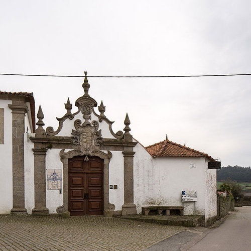 um prédio branco com uma porta de pedra e um sinal de estacionamento ao lado