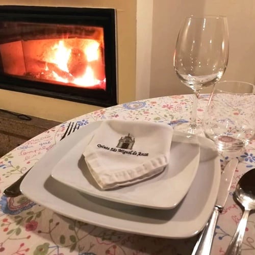 una mesa con platos y copas frente a una chimenea