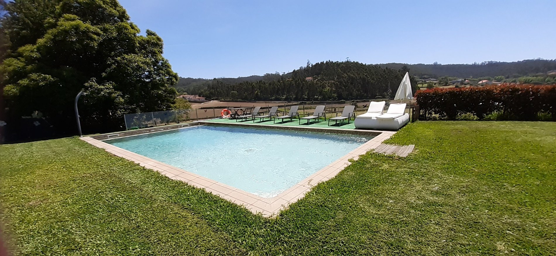 uma grande piscina com uma casa ao fundo