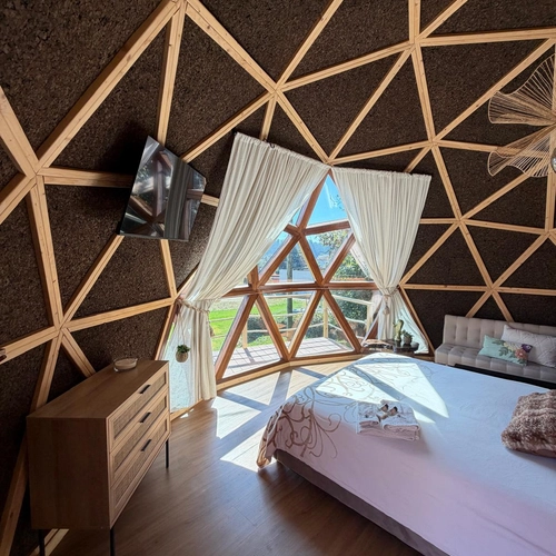 Quarto em domo geodésico com vista para natureza, cama confortável e móveis rústicos. Quinta São Miguel de Arcos