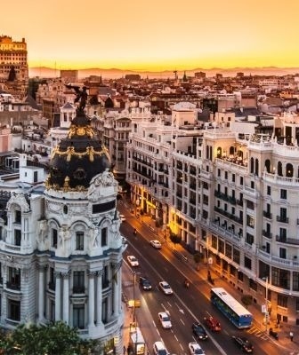 une vue aérienne d' une ville au coucher du soleil avec des bâtiments et des rues .