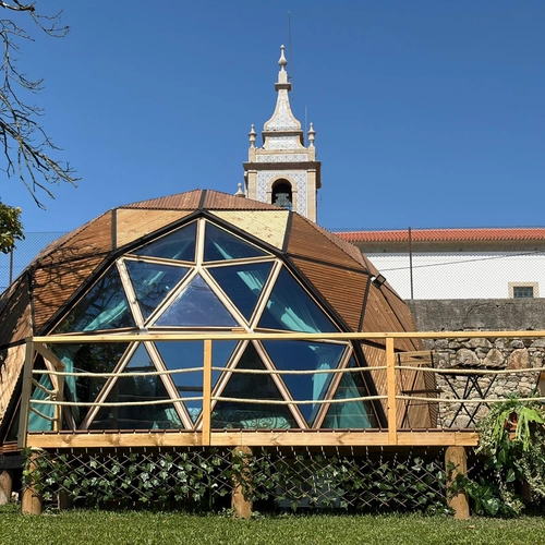 Quinta São Miguel de Arcos: domo geodésico com varanda de madeira e vistas para a igreja.