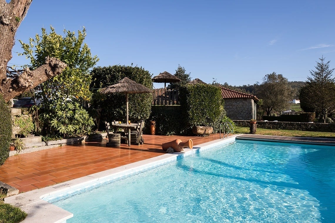 uma grande piscina com uma mesa e cadeiras ao redor