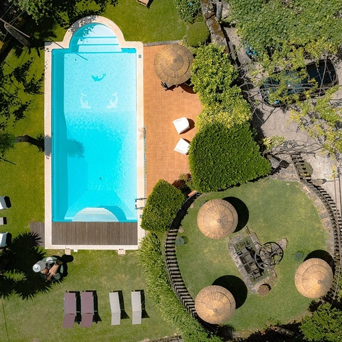 uma vista aérea de uma grande piscina com cadeiras e guarda-chuvas