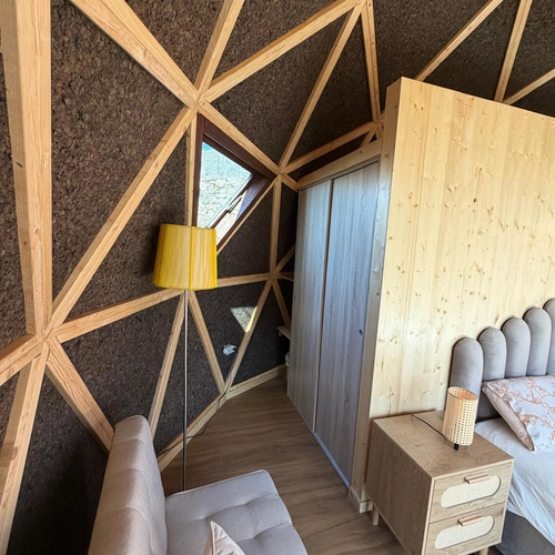 Quarto geodésico moderno com sofá, cama e luminária; ideal para Quinta São Miguel de Arcos.