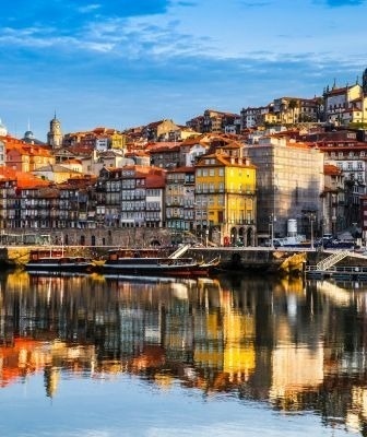 une ville au bord d' une rivière avec des bâtiments colorés et des reflets dans l' eau .