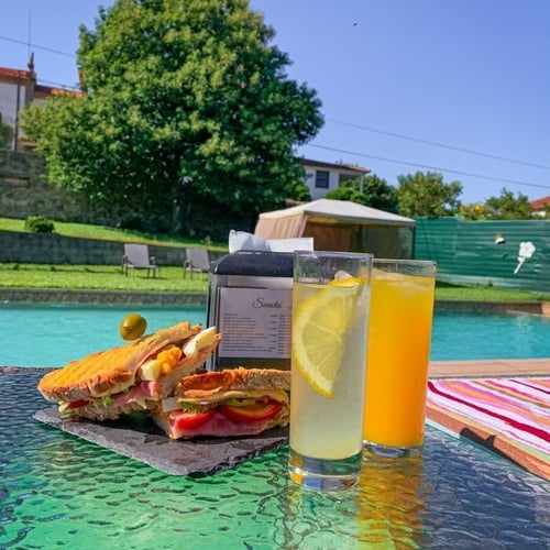 una mesa con un sándwich y un vaso de zumo de naranja