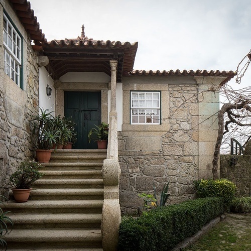 uma casa de pedra com escadas que levam até a porta