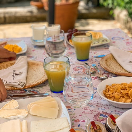 una mesa llena de comida y bebidas con un frasco de mermelada en la bandeja