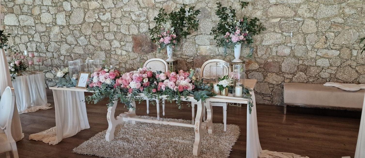 uma mesa com vasos cheios de flores e uma vela