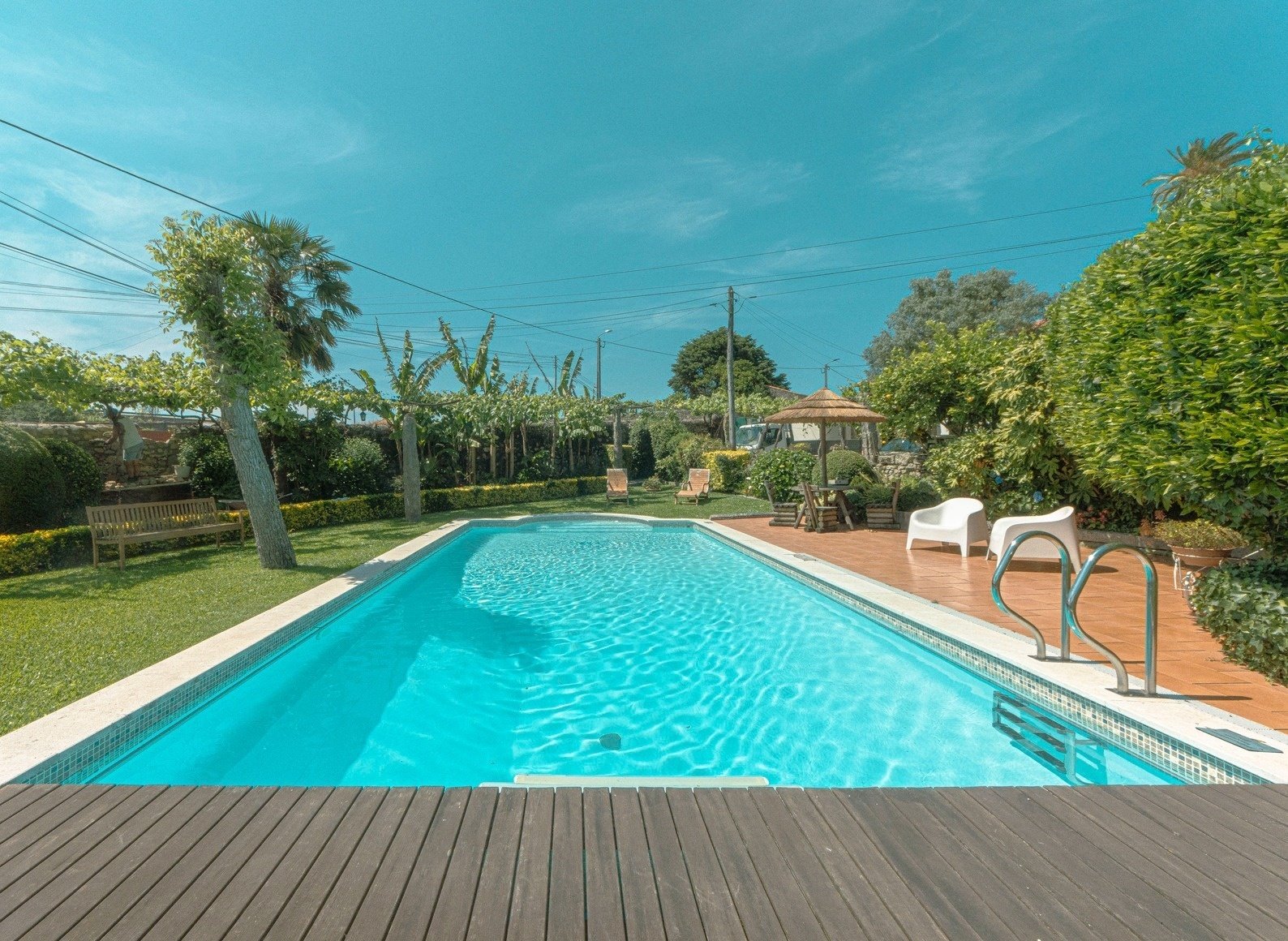 uma grande piscina com uma mesa e cadeiras ao redor