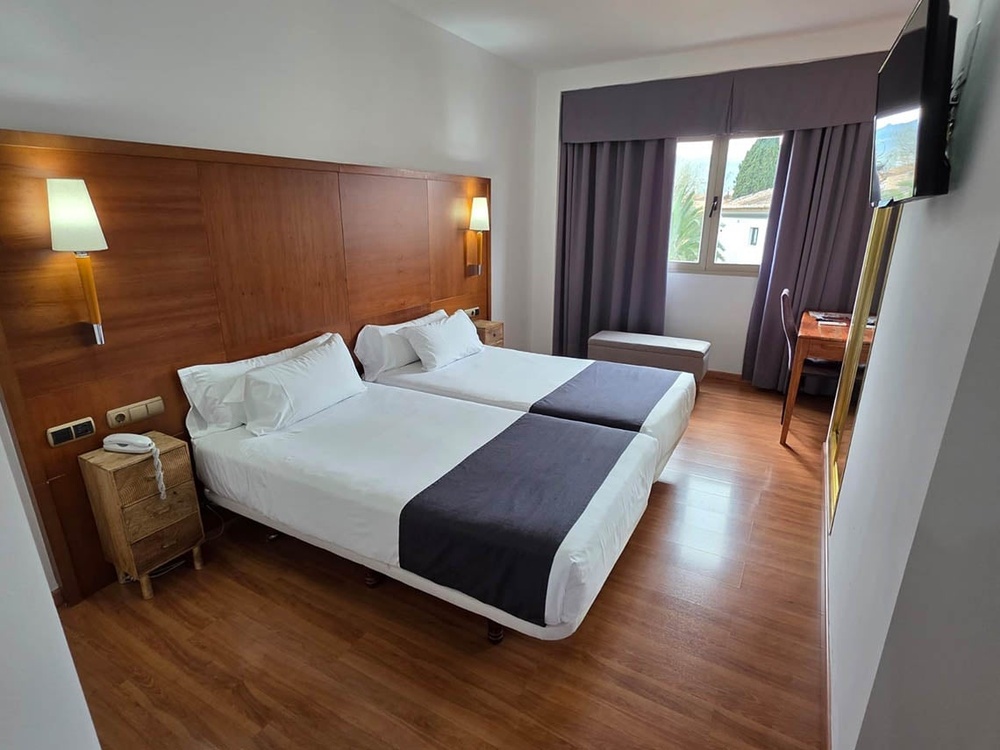 a hotel room with two beds and a bottle of wine on the bed
