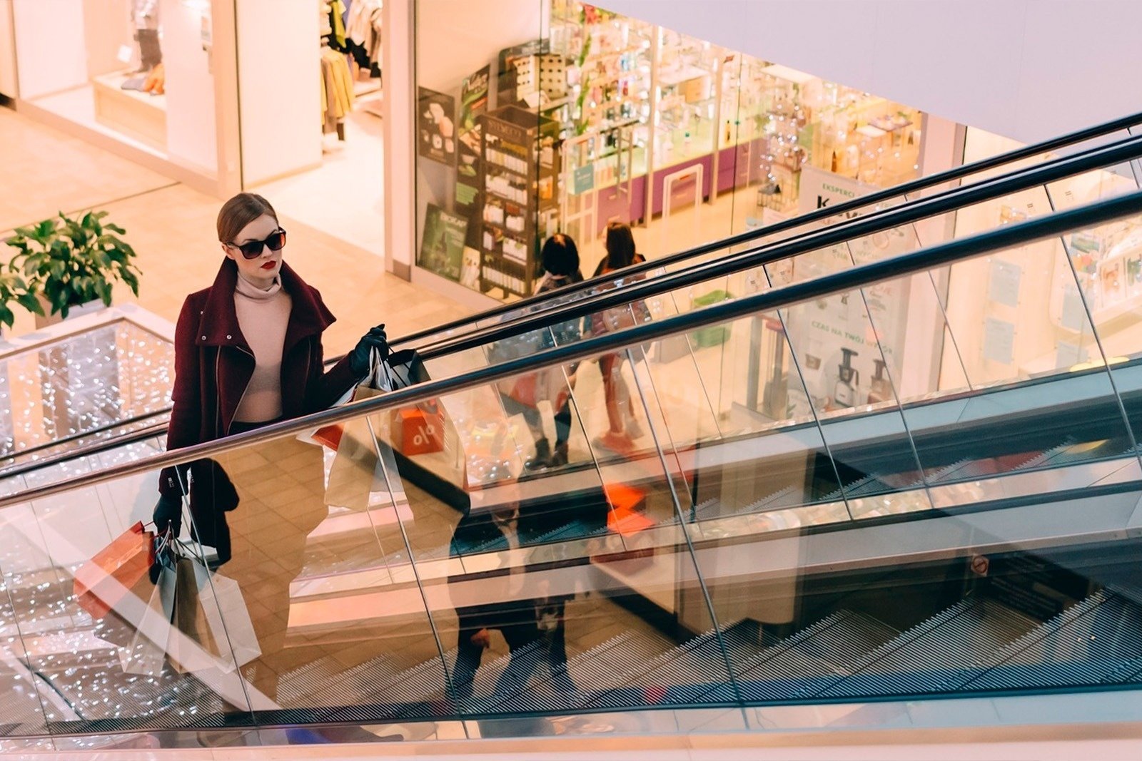 a woman in a white shirt is standing on an escalator